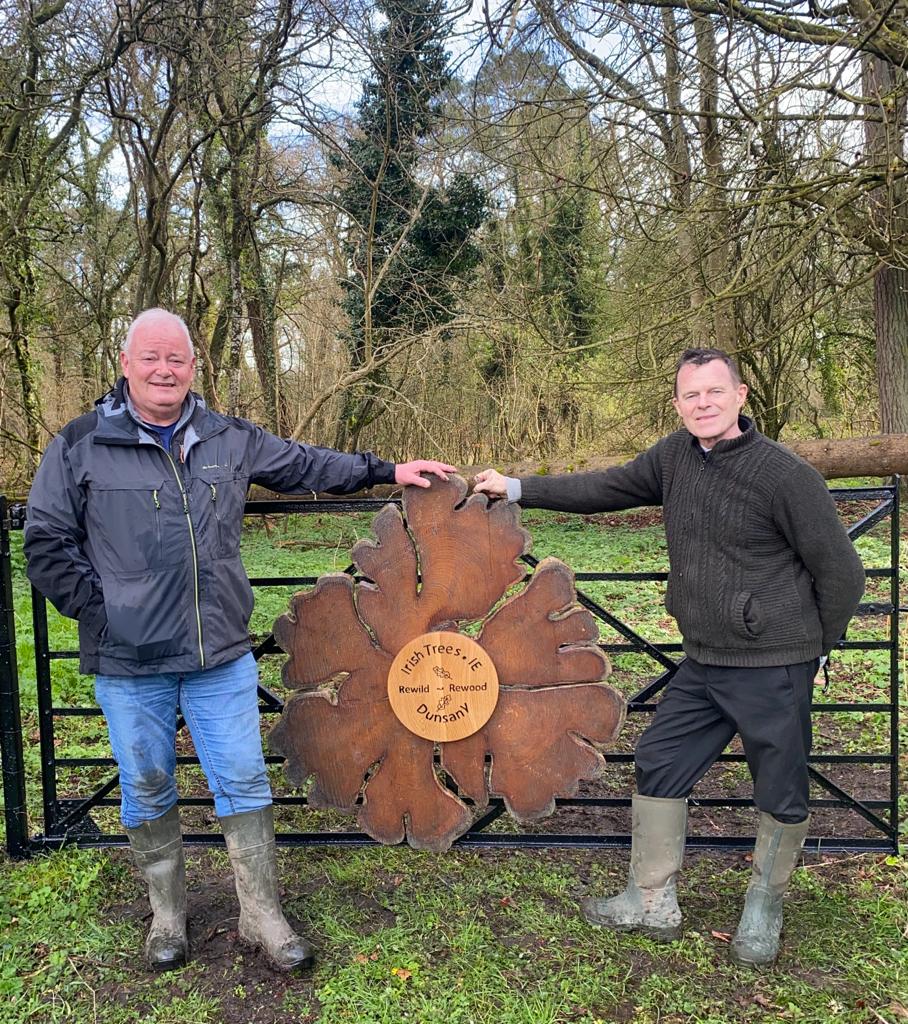 image of Bob Hamilton and John Doran - Irish trees at a signed gate at Dunsany Nature Reserve sign on the gate reads Rewild Rewood Irish Trees at Dunsany